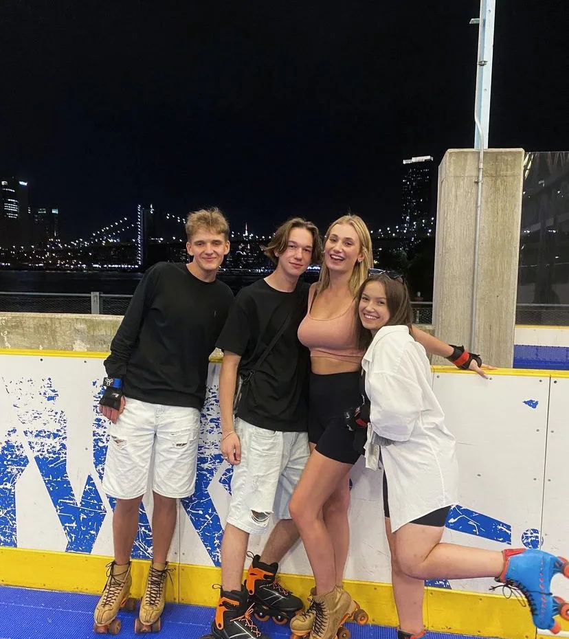 four friends posing against the wall at night for a picture