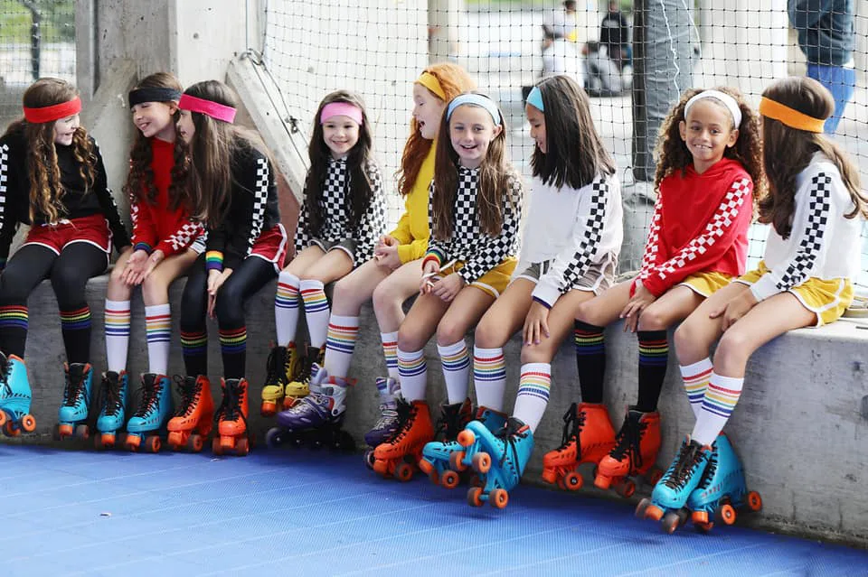 group of nine girls sitting on the wall having fun and talking