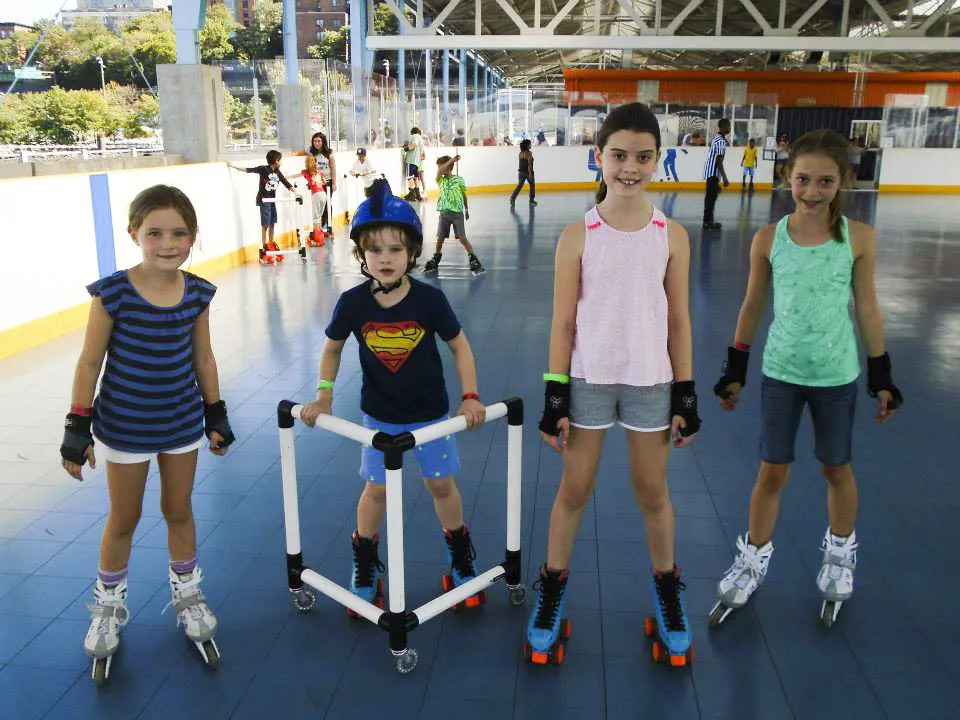 four young kids skating in a line