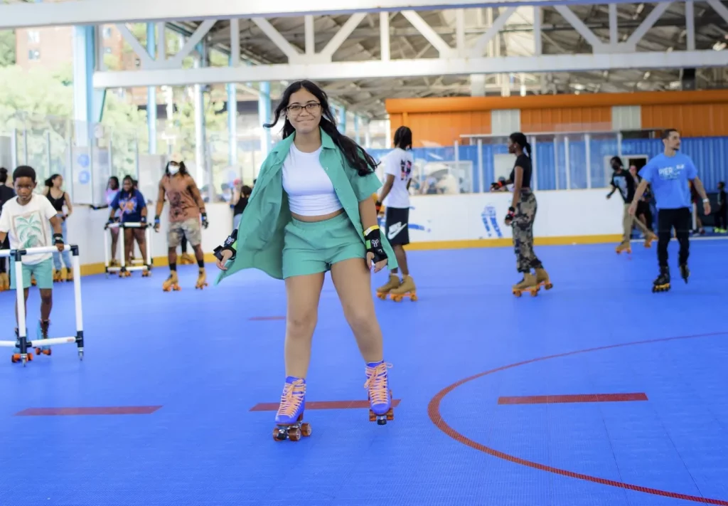 girl in green shirt and shorts skating right towards the camera