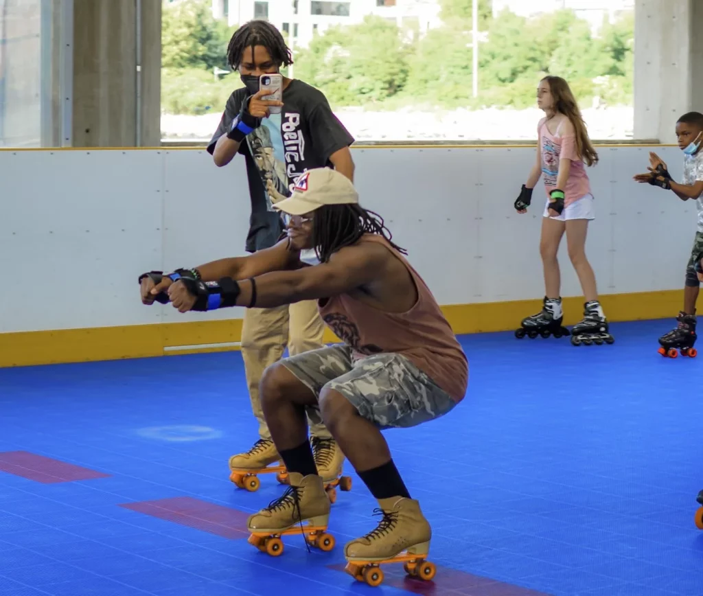 teenage boy filming his friend with an iphone squat down while skating